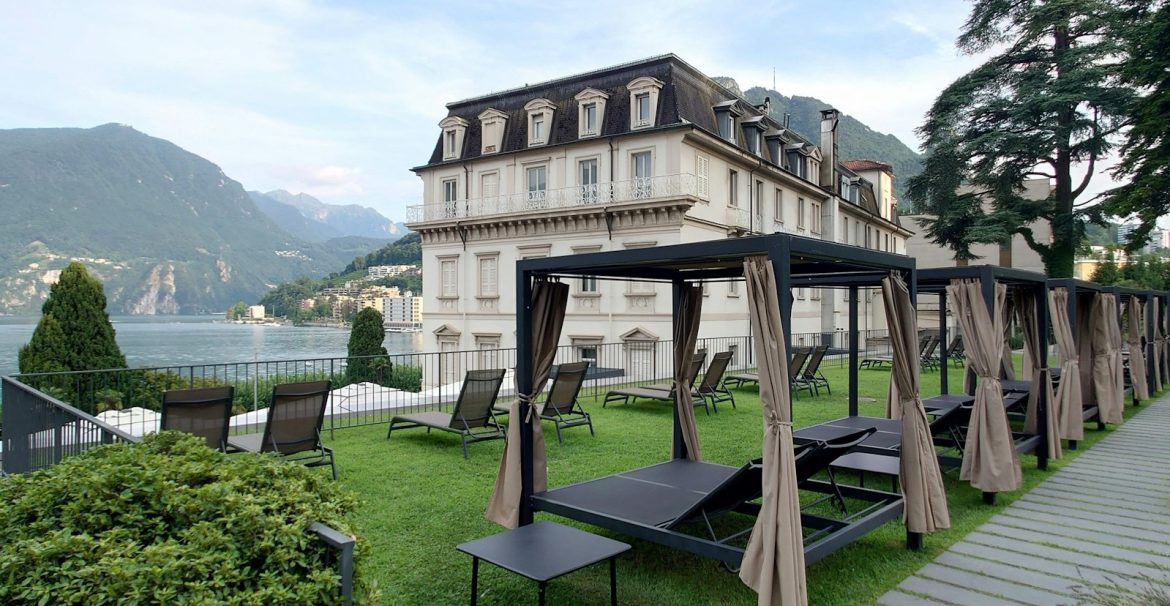 A large building with a lawn and picnic tables in front of it