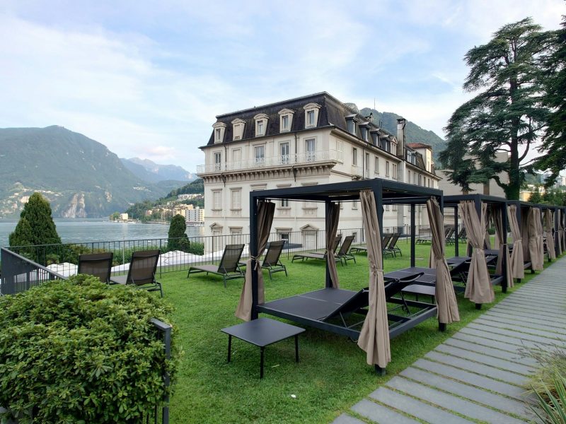 A large building with a lawn and picnic tables in front of it